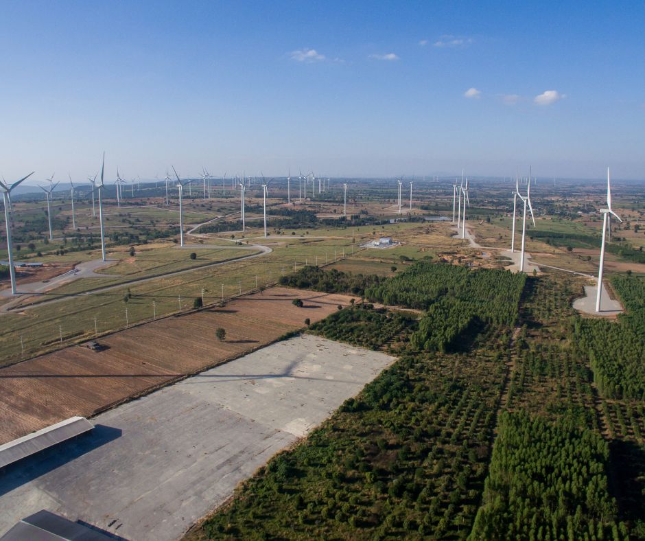 Das Bild zeigt eine zerschnittene Landschaft mit Windrädern und einzelnen kleinen Waldparzellen.